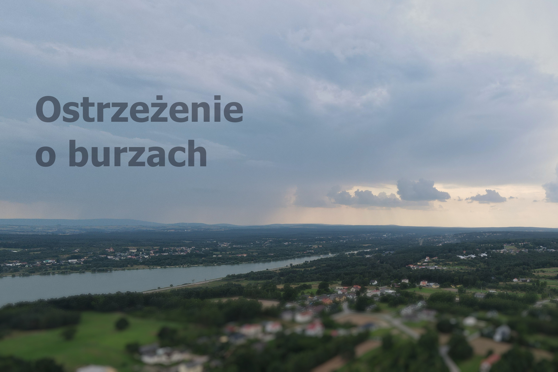 Zdjęcie okolic nad Zalewem Brodzkim - w&nbsp;oddali chmura burzowa. Na zdjęciu napis "Ostrzeżenie o&nbsp;burzach".