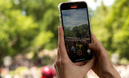 Widać ręce trzymające telefon w czasie nagrywania wideo. Tekst: Konkurs filmowy dla młodzieży.